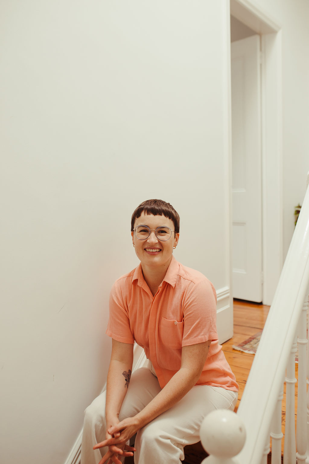 Chauncey Sjostedt seated on a staircase in soft natural light